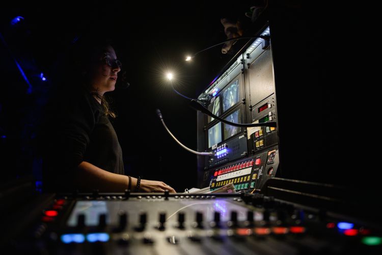 Deputy Stage Manager looking at screens at al control desk during a show